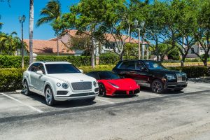 black rolls royce cullinan and red ferrari side by side