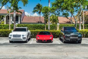 red ferrari black rolls royce cullinan front view three cars