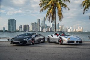 black lamborghini huracán evo alongside grey ferrari miami city view