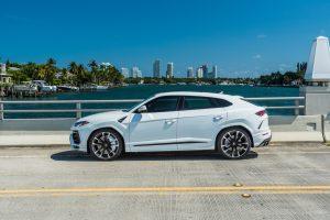 image of white Lamborghini urus rental side view