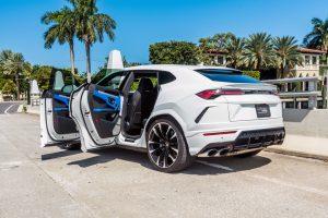 white lamborghini urus side view doors open available for rent